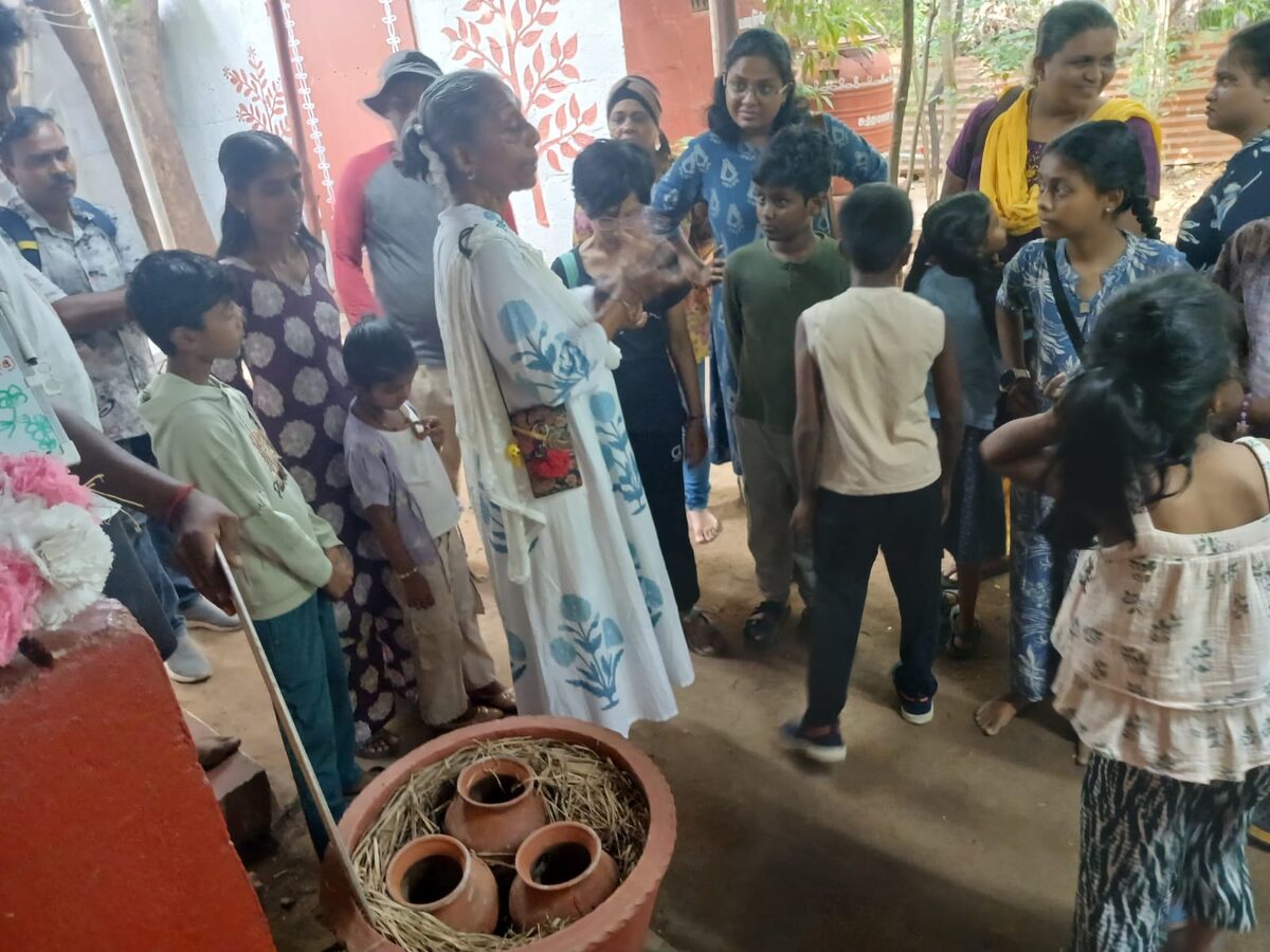 Santha Sheela Nair explaining the terracotta refrigerator — small clay pots nested in straw inside a larger terracotta vessel